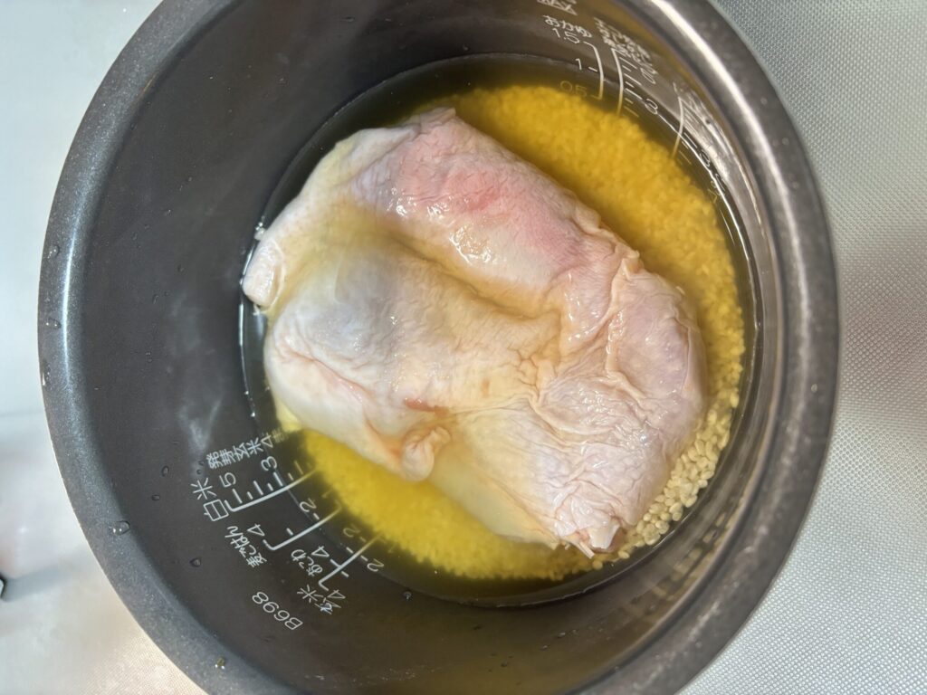 鶏もも肉と米を炊飯器に入れた状態
